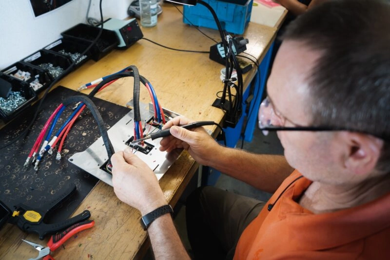 An engineer solders components onto a motherboard